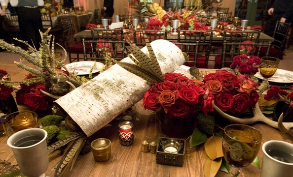 Birch logs, moss, pheasant feathers, moss-covered branches, deer antlers, and roses.