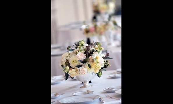 Hydrangeas, vendella roses, Sahara roses, white hypericum berries, dahlias, and cream stock, with accents of seeded eucalyptus in a silver footed bowl.