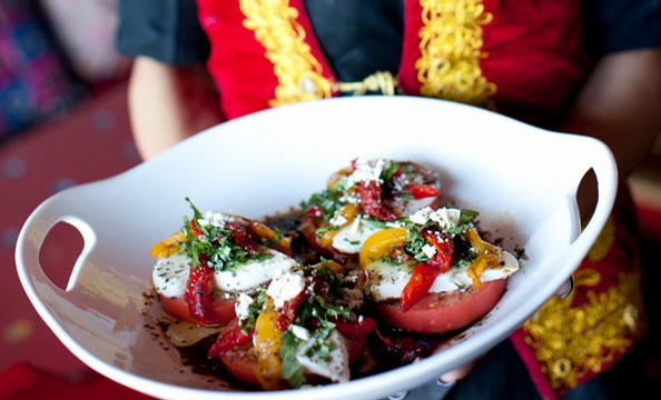 Alexandria Afghan restaurant Maizbon puts a vibrant twist on a tomato salad, with mozzarella, feta, roasted peppers, and herbs.