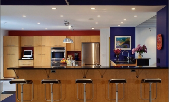 Bold paint colors and minimalist furniture and appliances give the kitchen an uncluttered look.