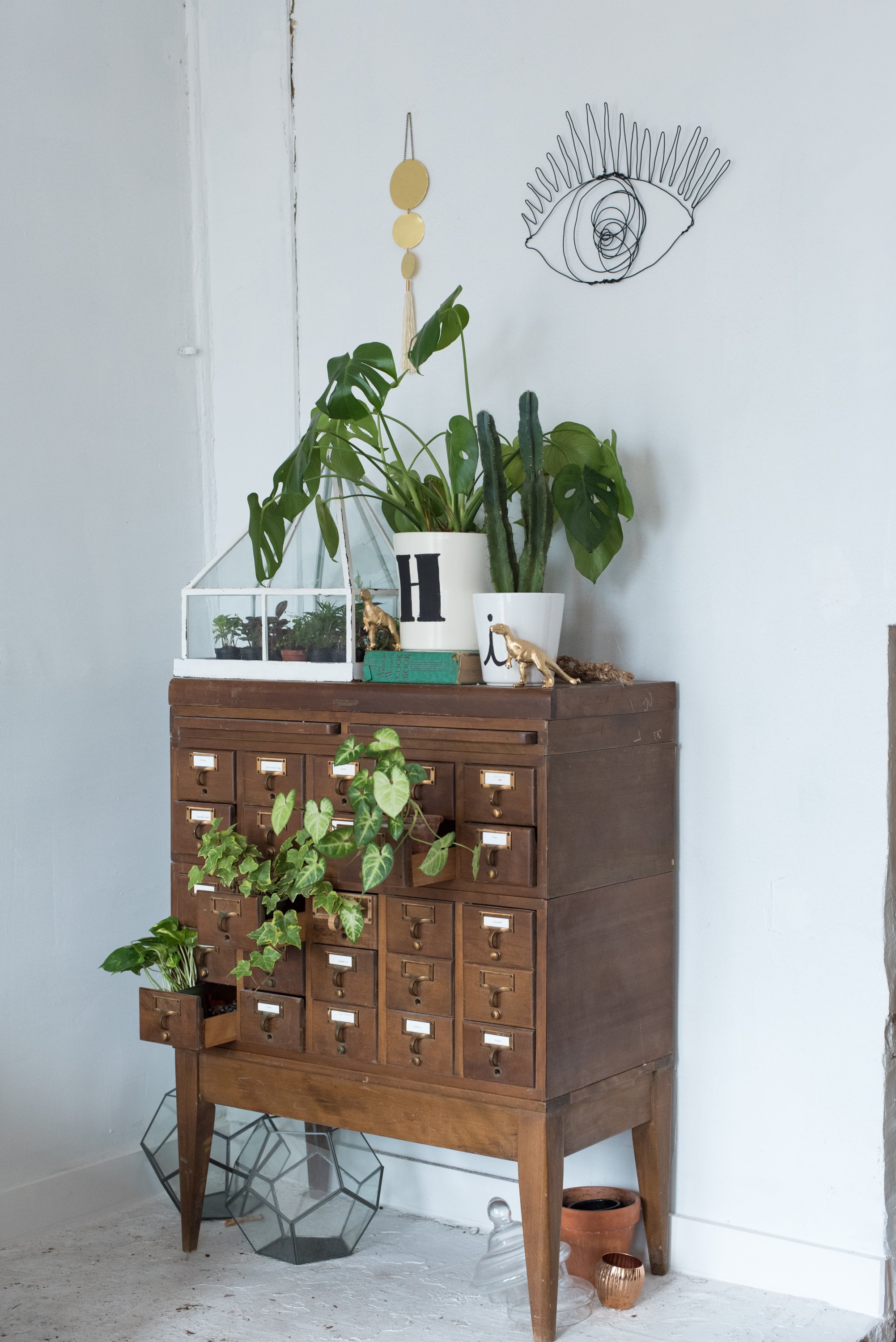 Lettered plant pots greet visitors on top of a card-catalog-cum-greenery-dispenser.