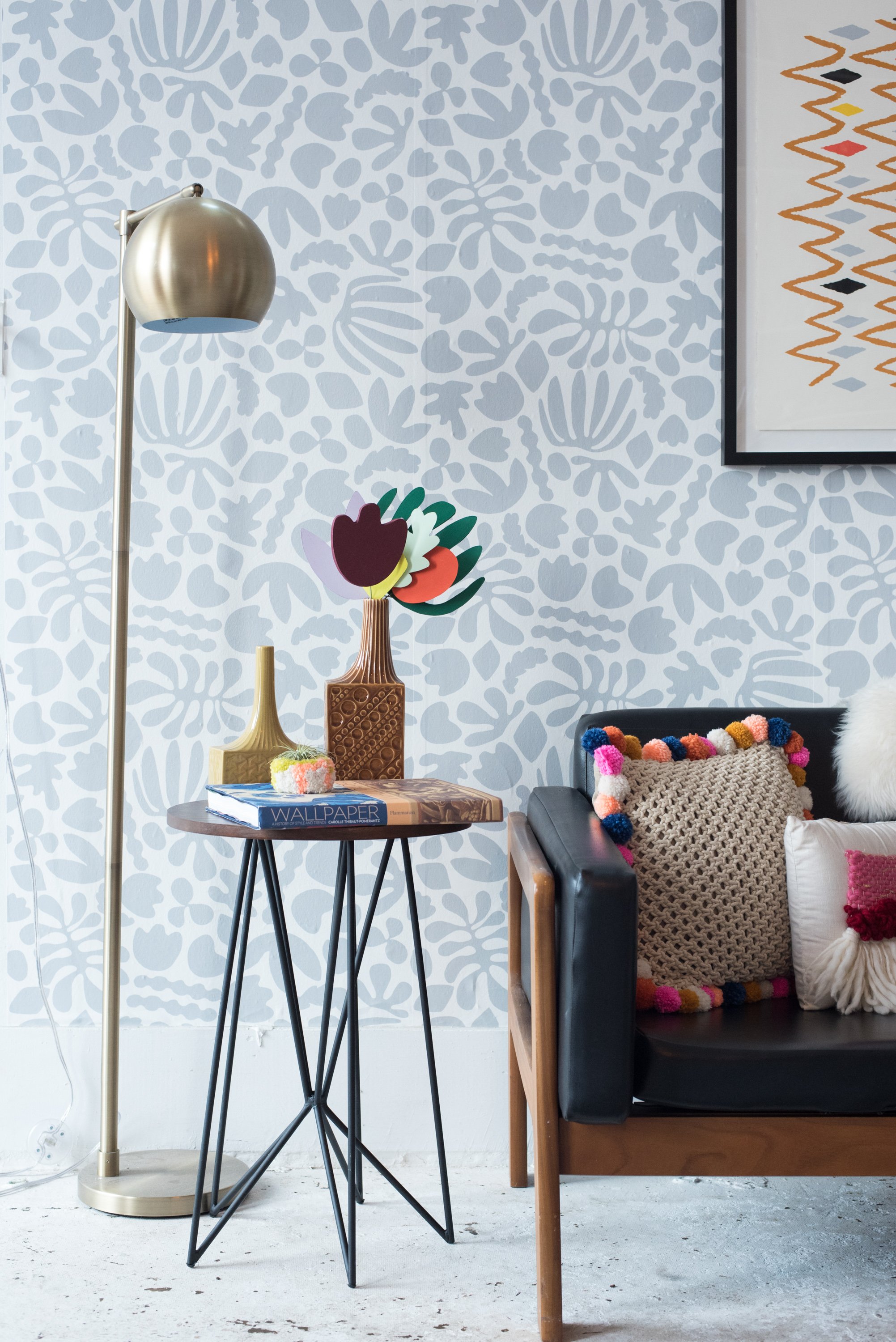 Zaremba's Matisse-inspired wallpaper forms a lively backdrop for the leather sofa and pom pom pillows.