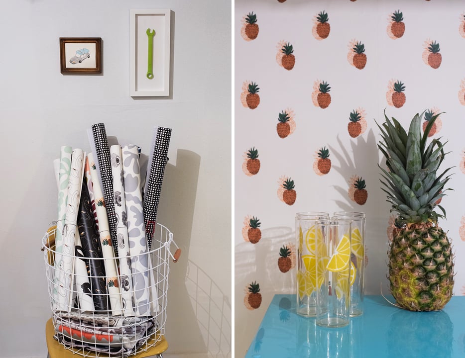 Sample rolls of Zaremba's whimsical wallpapers; the pineapple wallpaper turns a table and mini-fridge into a kitchen alcove.