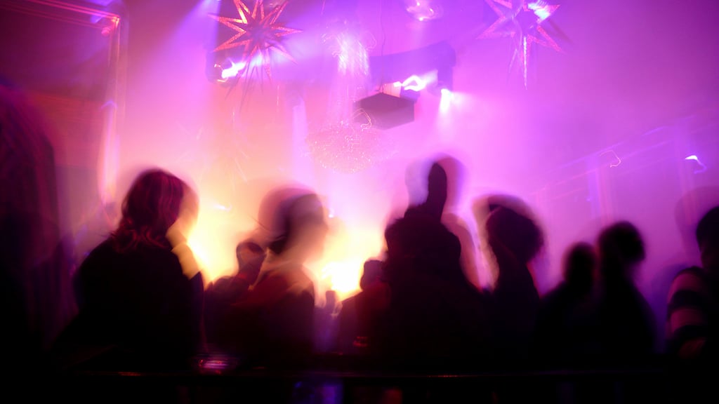 Nightclub scene with christmas decor and dance floor crowd in motion
