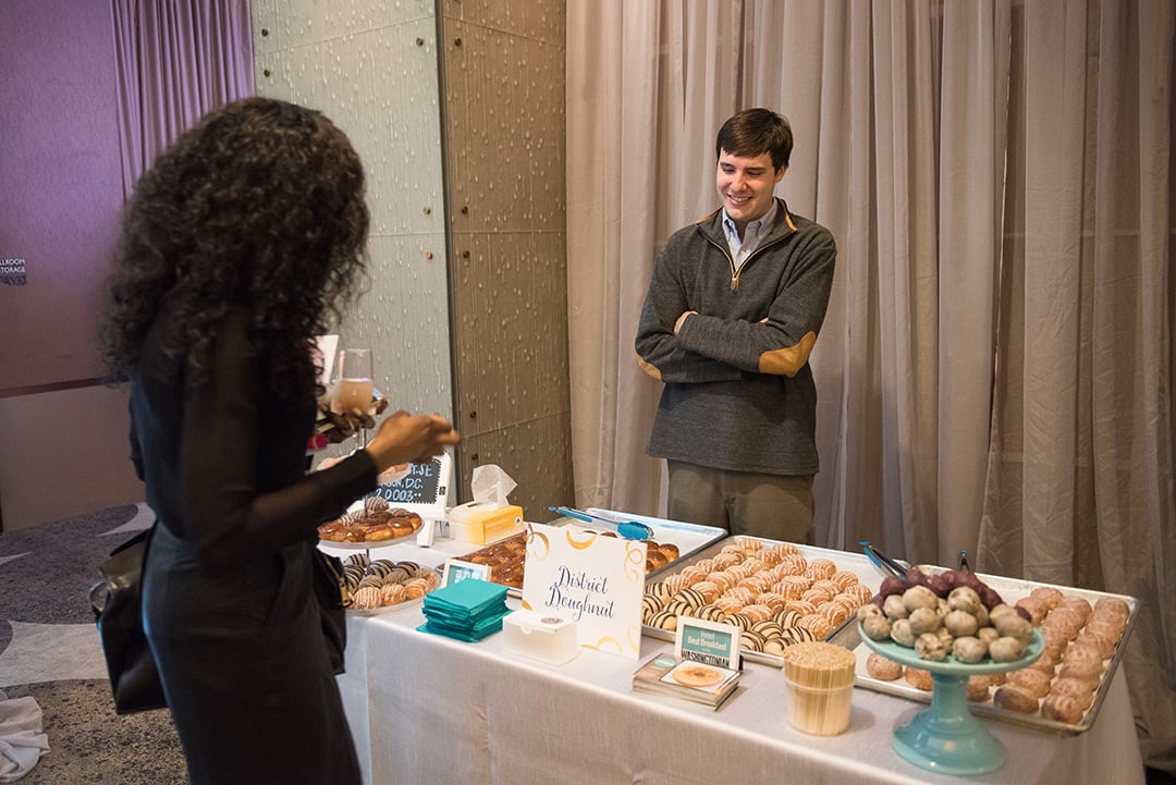 Will Hand from District Doughnuts looks on as a guest decides which delicious sample to try. 