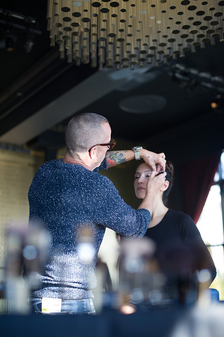 Makeup artist Carl Ray applies the finishing touches to a model before the runway show.