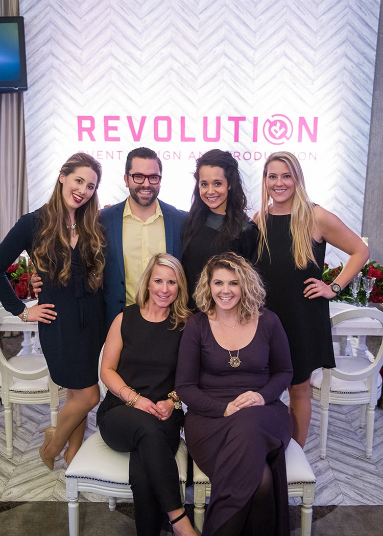 Hannah Cohen, Danny Tippett, Renee Diodonet, Olivia Brown, Caroline Clauss, and Katie Kirby from Revolution Events pose in front of their booth.