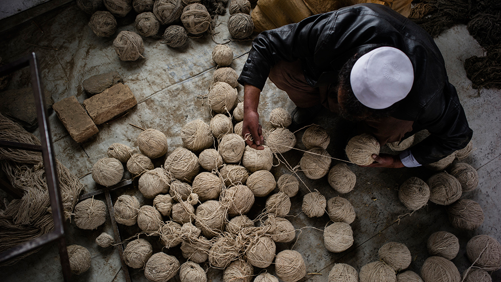 An Afghan artisan with wool to be woven into rugs. Photograph of Afghan Artisan by Lorenzo Tugnoli