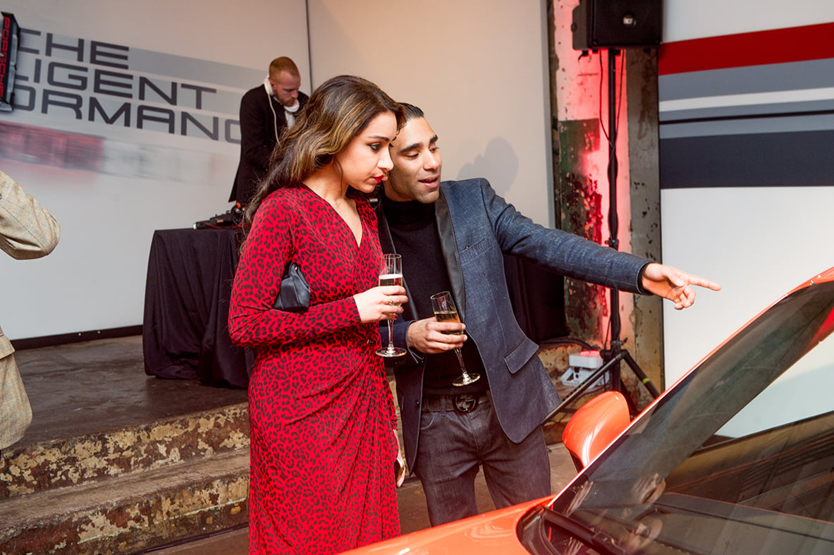 Two guests admire one of the Porsches on display at the event. 