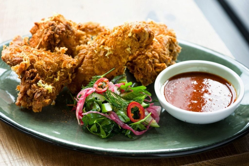 Shareable family-style platters include Greek fried chicken--served half or whole--with spiced honey. 