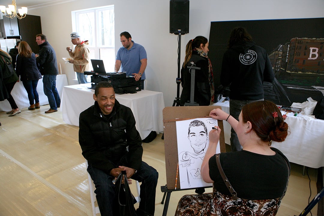 Robert Horton poses for a caricature drawing at the grand opening event. 