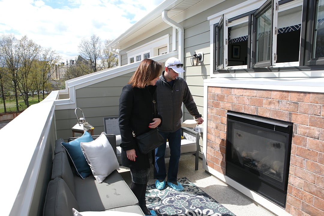 Kim Earls and Andrew Bolton admire the indoor / outdoor fireplace on the rooftop terrace. 