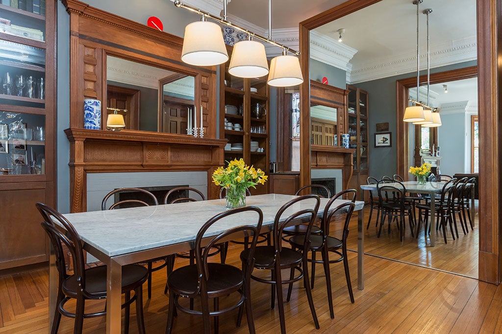 Dining room includes a second mantle and a mirrored, sliding wall which opens to the kitchen. Photograph: Sean Shanahan