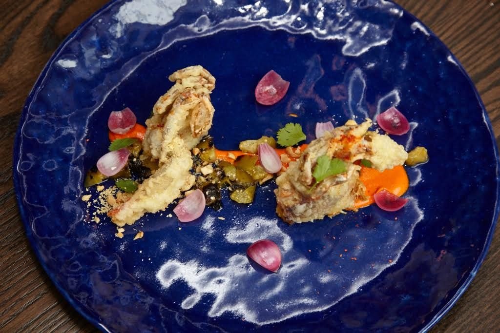 Chef Daniel Perron makes creative plates, such as this crispy soft-shell crab sauced with spicy peanut romesco. 