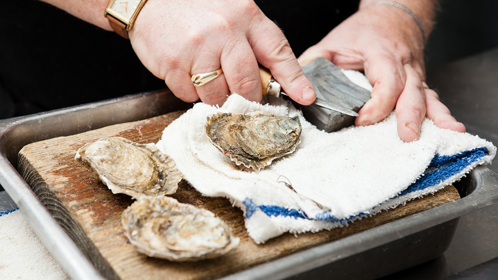 Chesapeake Bay restaurants: Oyster shucker Pete Woods serves up oysters on the half shell at Rappahannock Oyster Company's tasting room, Merroir. Photograph by Will Parson/Chesapeake Bay Program.