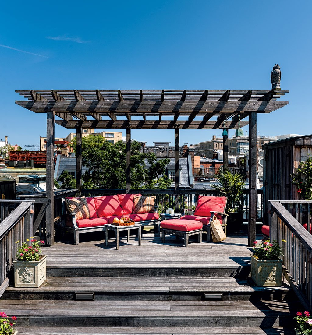 A seating area underneath a pergola offers shade for family guests.