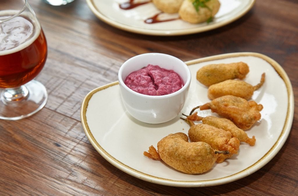 Chef Vikram Sunderam incorporates a few trendy ingredients in the menu, like these shishito pepper fritters with pickled onion chutney.