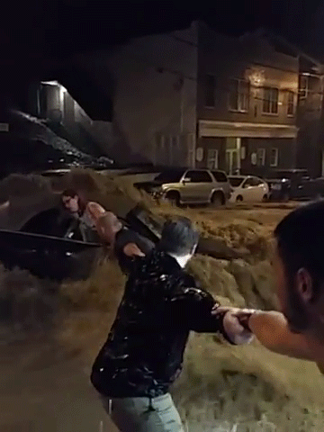 A human chain forms to rescue a woman trapped in her car in Ellicott City during flash flooding. 