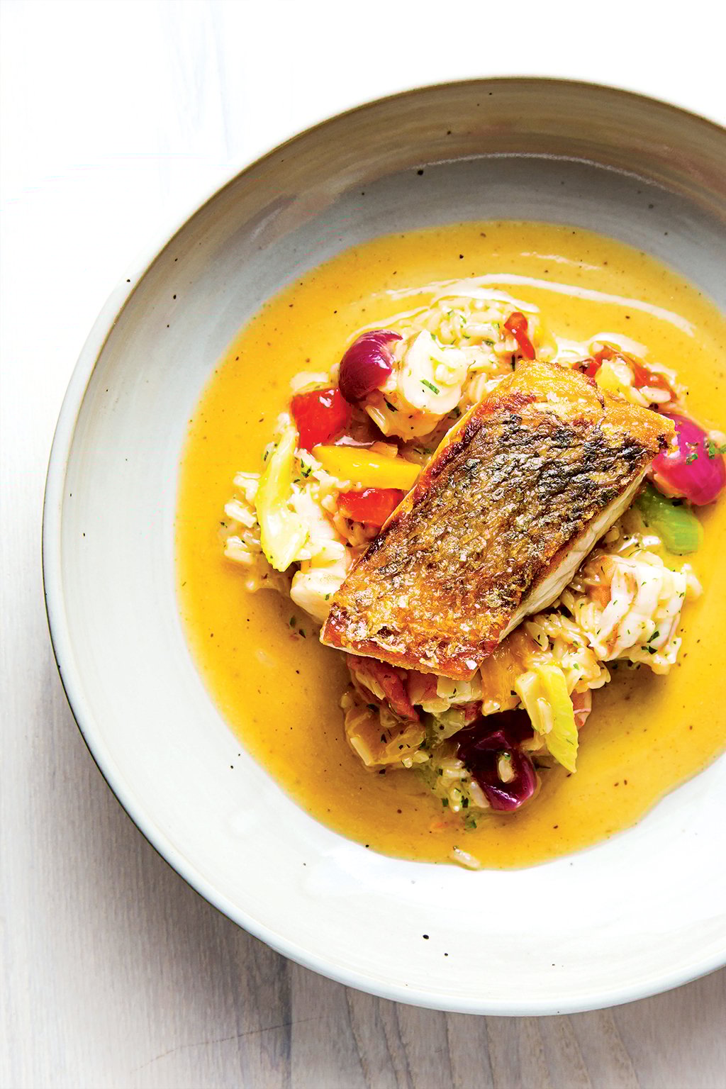 kinship-restaurant-review-eric-ziebold-redfish-shrimp-jambalaya - Washingtonian At Kinship, redfish sits atop shrimp jambalaya seasoned with Old Bay.