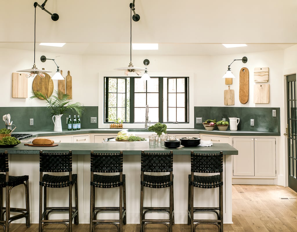 Organize vacation house. Removing upper cabinets made the kitchen feel much larger. In their place, Liess hung a collection of vintage cutting boards. Photograph by Helen Norman.