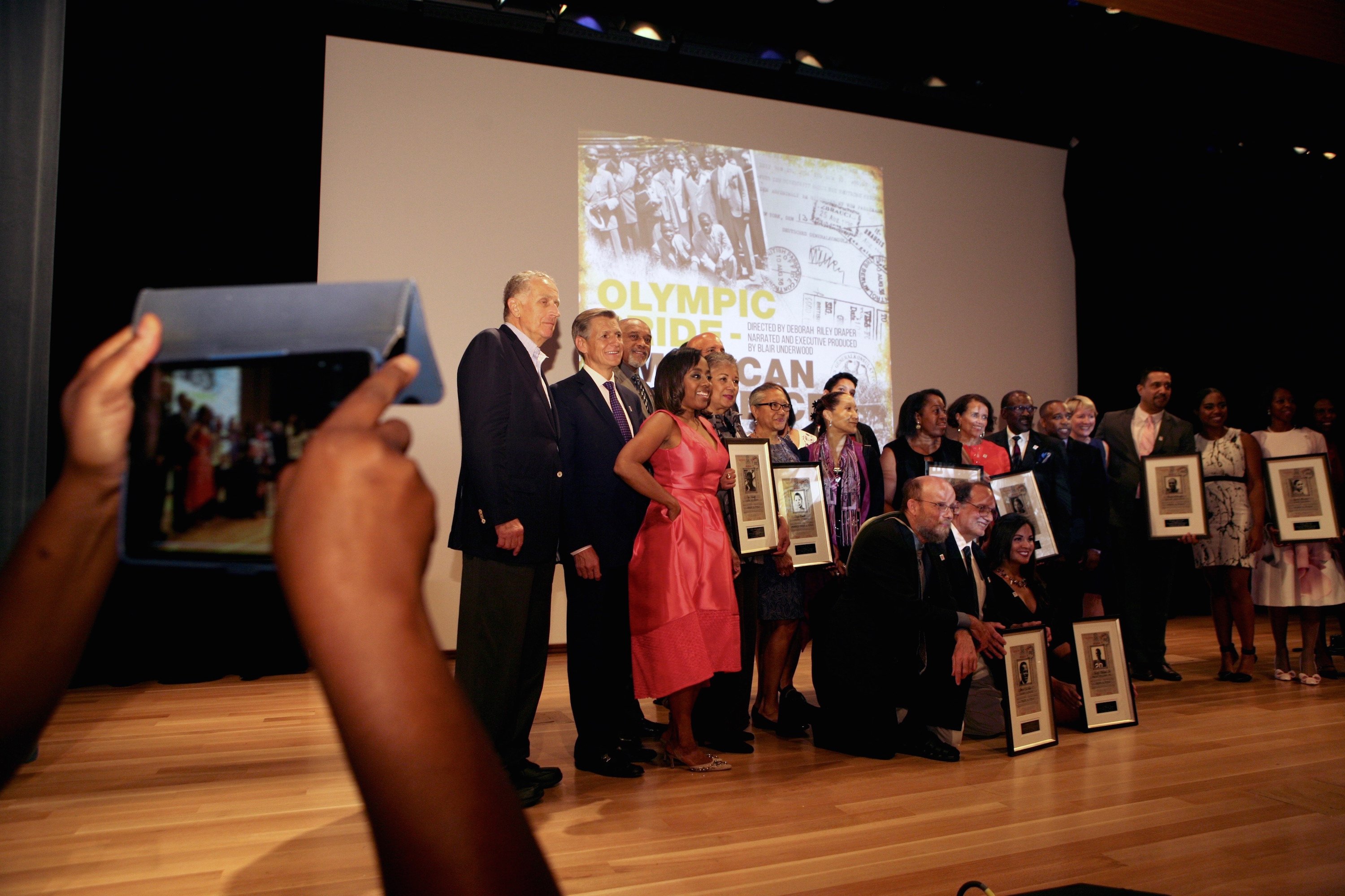 Families of the 1936 athletes pose for a photo to commemorate the day. 