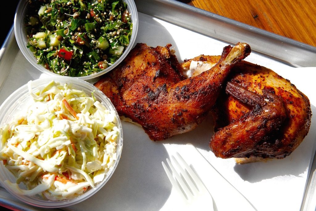 A platter of brined, smoked, and spiced chicken comes with a choice of two sides (here: slaw and sprouted tabouli).