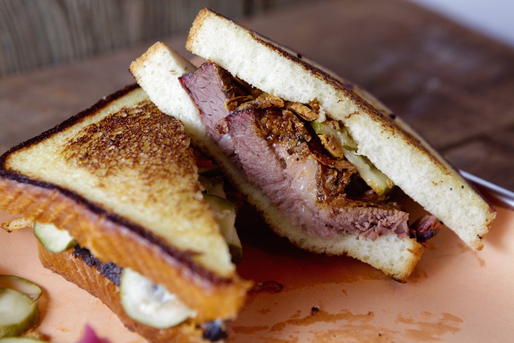 The Club with smoke turkey, pork belly, avocado, tomato, and garlic aioli on Texas toast.