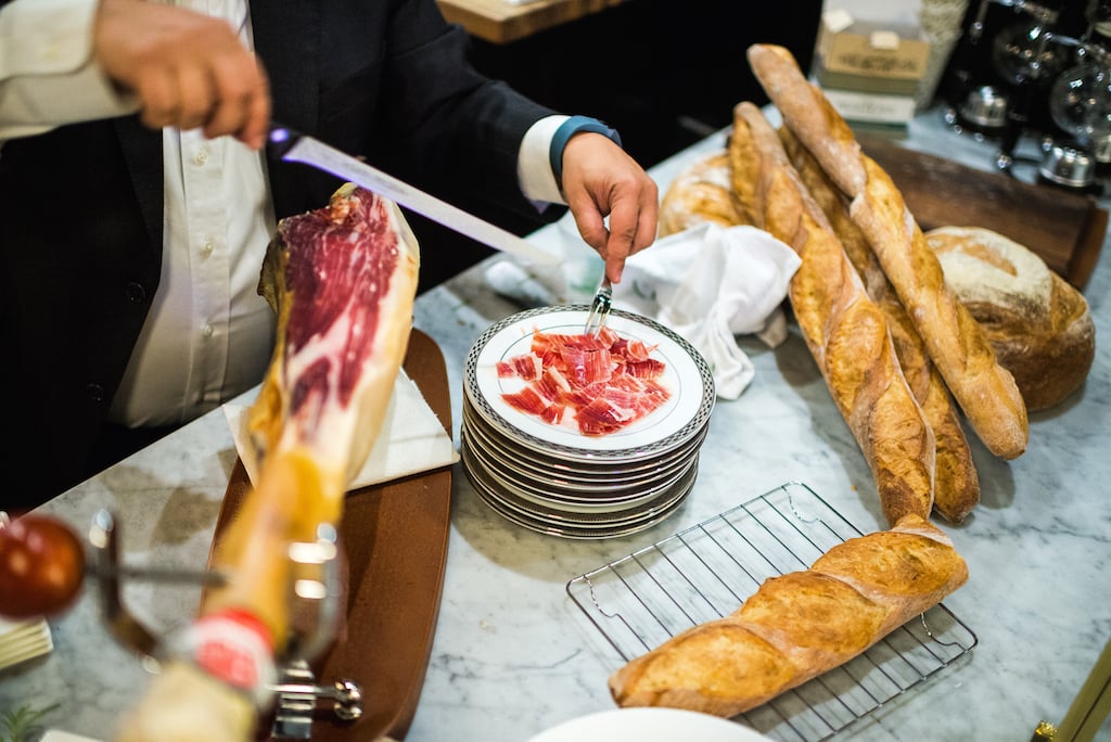 Servers shave slices of prized "jamon Iberico de Bellota" alongside fresh bread. 