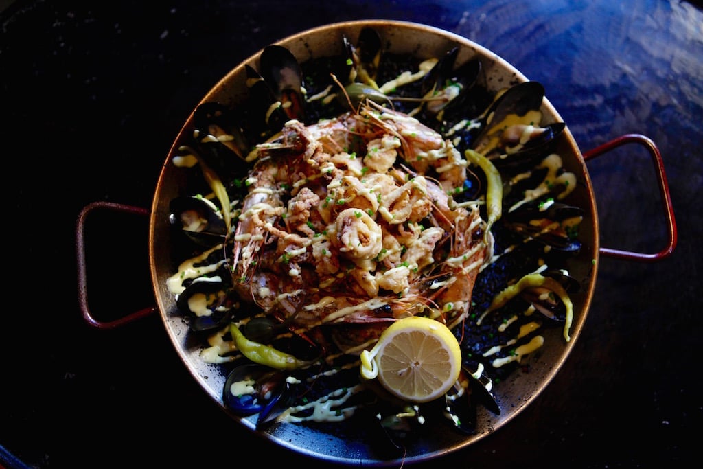 Three styles of paella are served by the pan, including this seafood variety. 