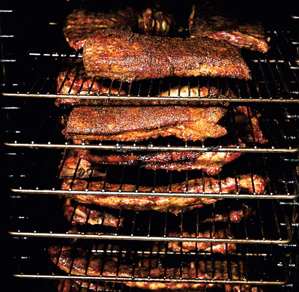 Ribs, sprayed in pickle brine, go into the smoker around noon.