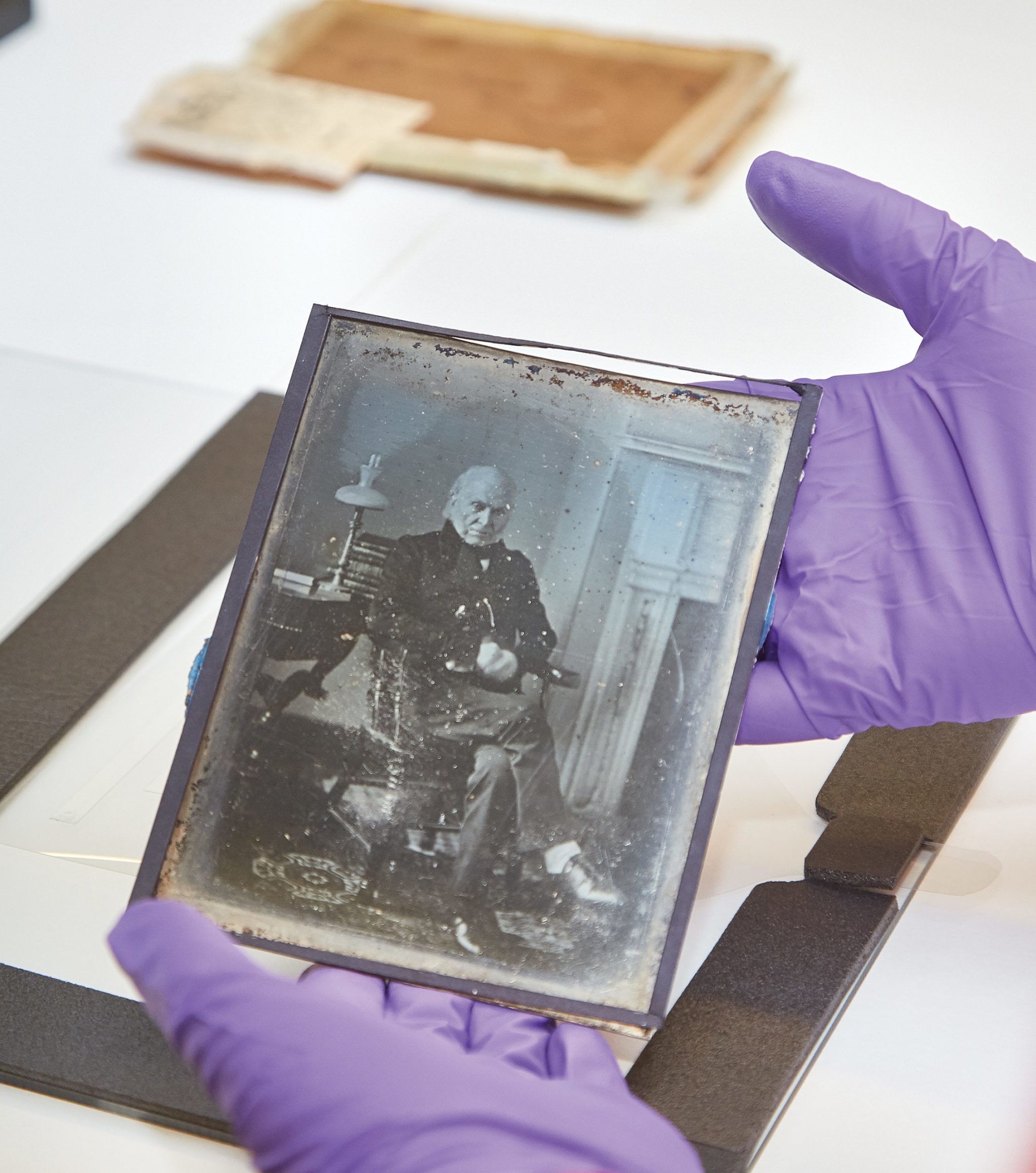 A museum conservator holds the 1843 Adams photograph. Photograph by Jeff Elkins.