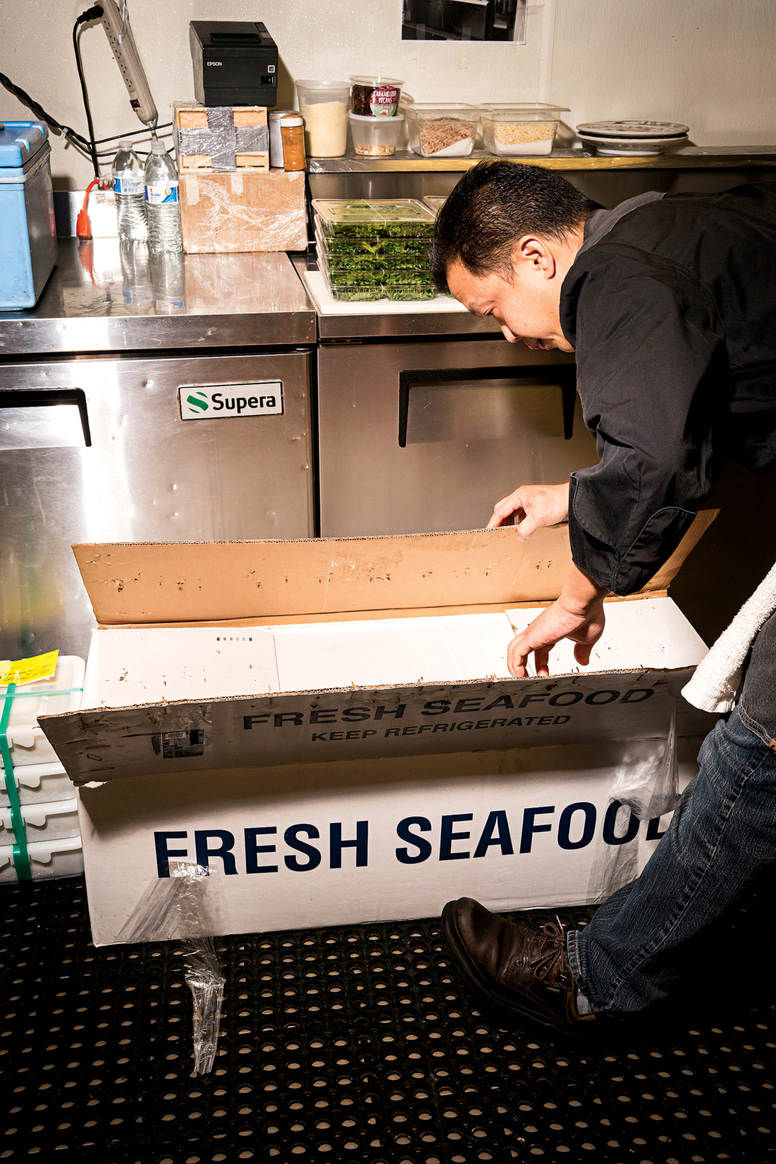 Piter inspects the daily shipment of seafood, most of which comes from Tokyo's famous Tsukiji market. Piter inspects the daily shipment of seafood, most of which comes from Tokyo's famous Tsukiji market. Photograph by Scott Suchman.