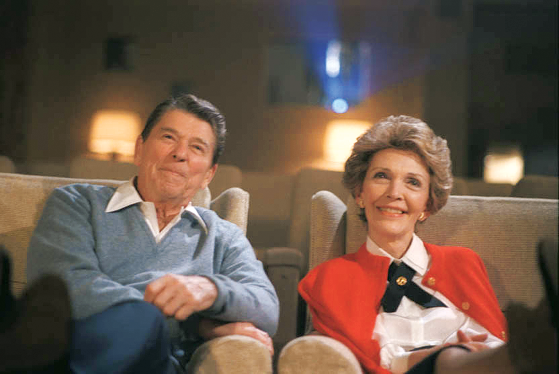 Ronald and Nancy Reagan watch a movie in the White House theatre.