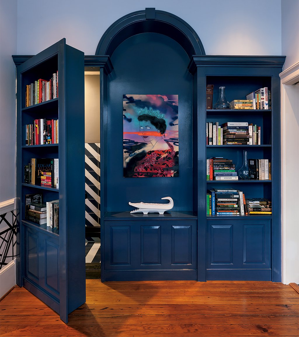 A panel of built-in shelving in the dining room doubles as a door that hides the powder room. Photograph by Mark Luthringer.