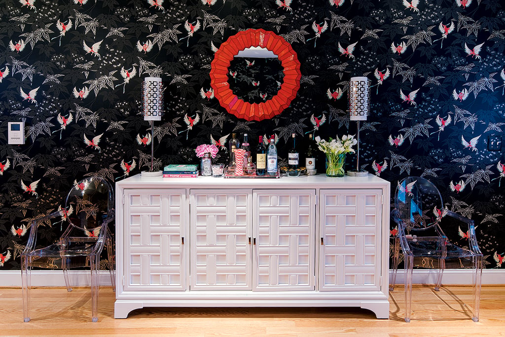 The bird-patterned wallpaper by Osborne & Little plays off the hot-pink vintage dining chairs. Photograph by John Magor.