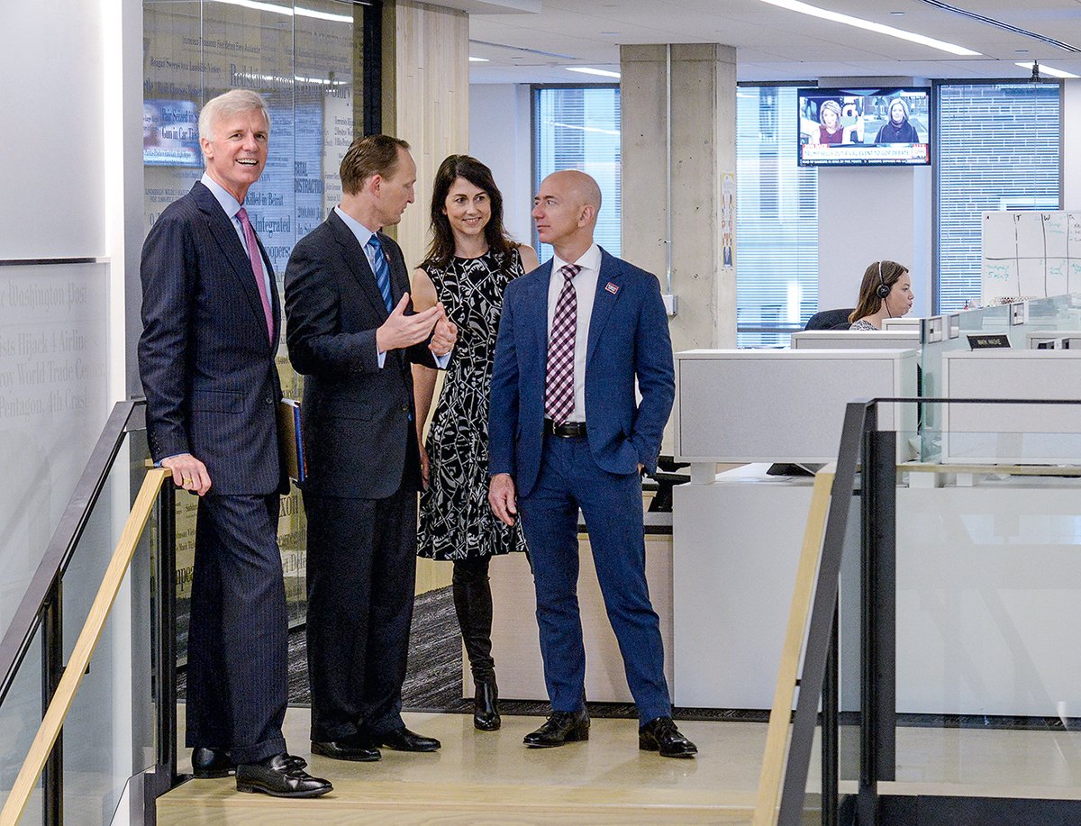 Touring the Post with MacKenzie and publisher Fred Ryan (far left). When Post execs have visited the Bezos estate outside Seattle, Bezos has made breakfast. Photograph by Bill O’Leary/Washington Post via Getty Images.