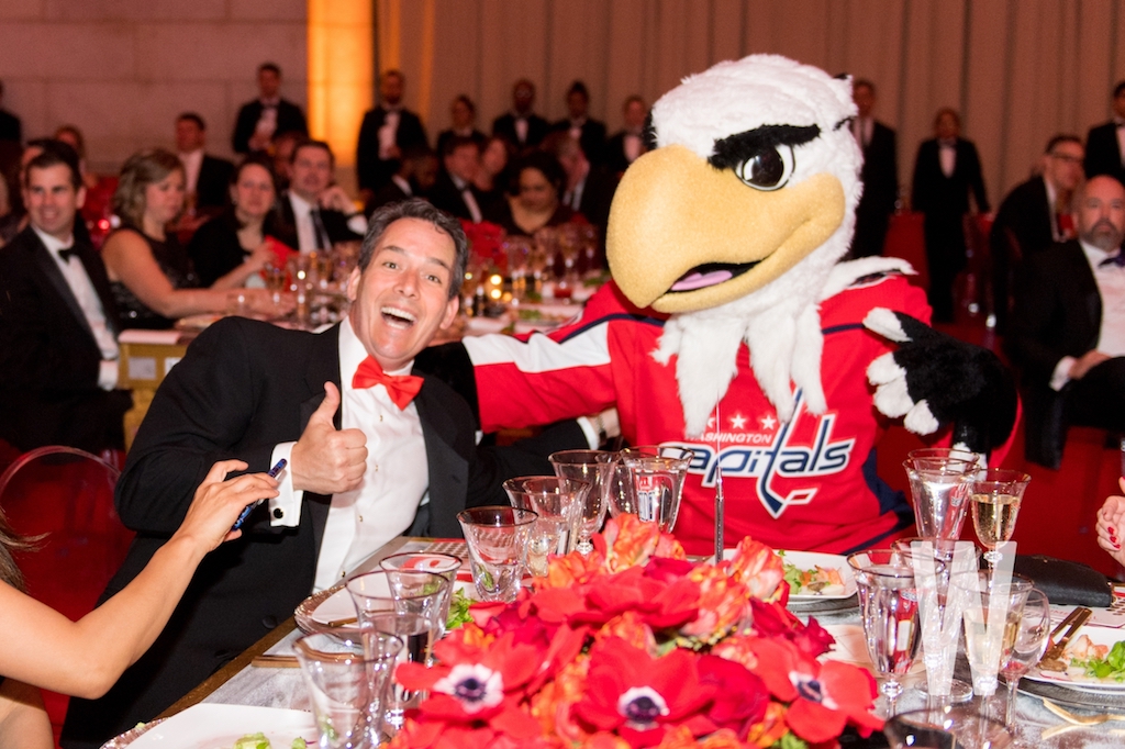 A guest mugs with the Washington Capitals' Slapshot mascot.