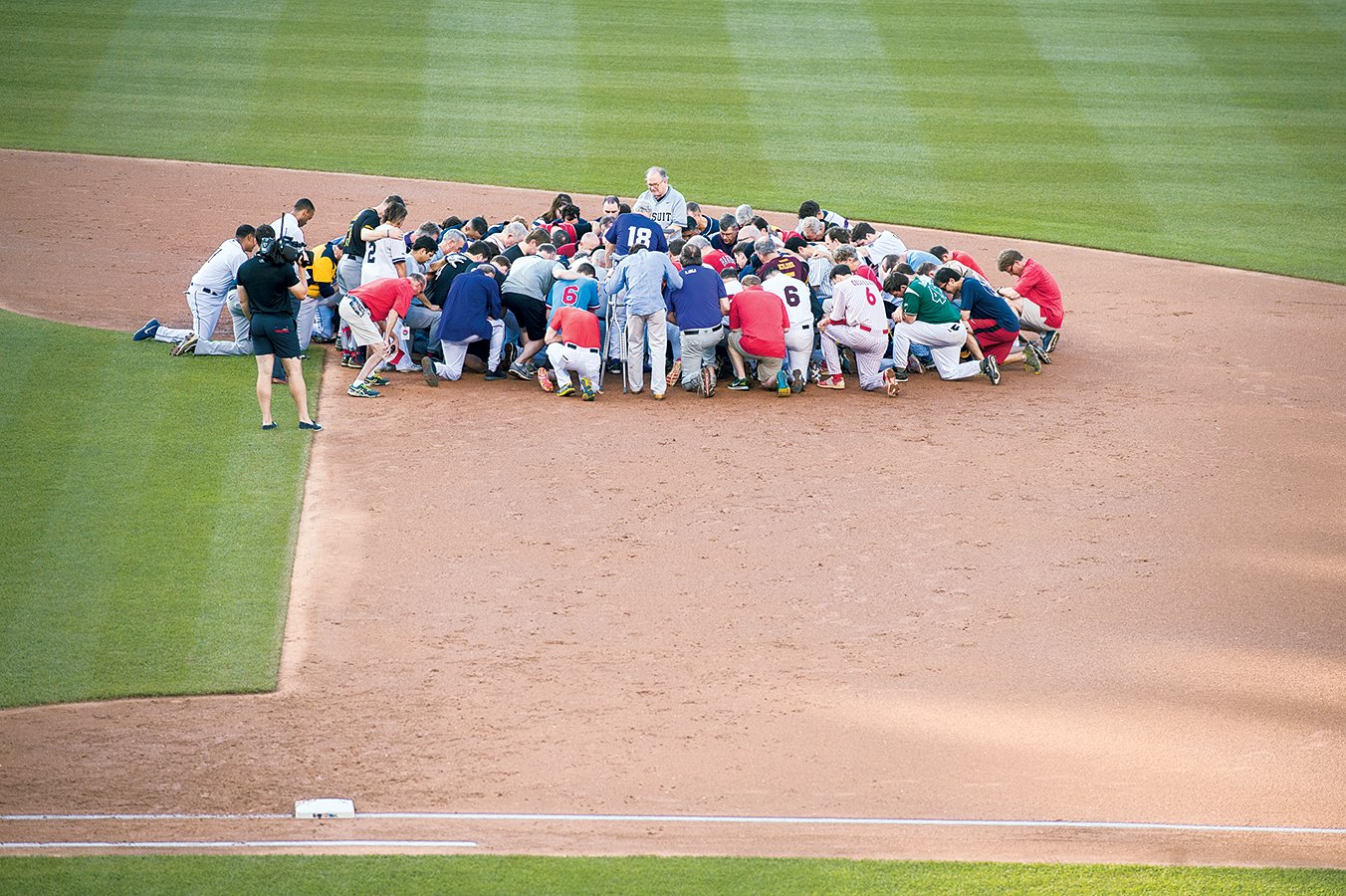 The next day, the game went on as planned, with players praying before the first pitch. Photograph Alex Wong/Getty Images.