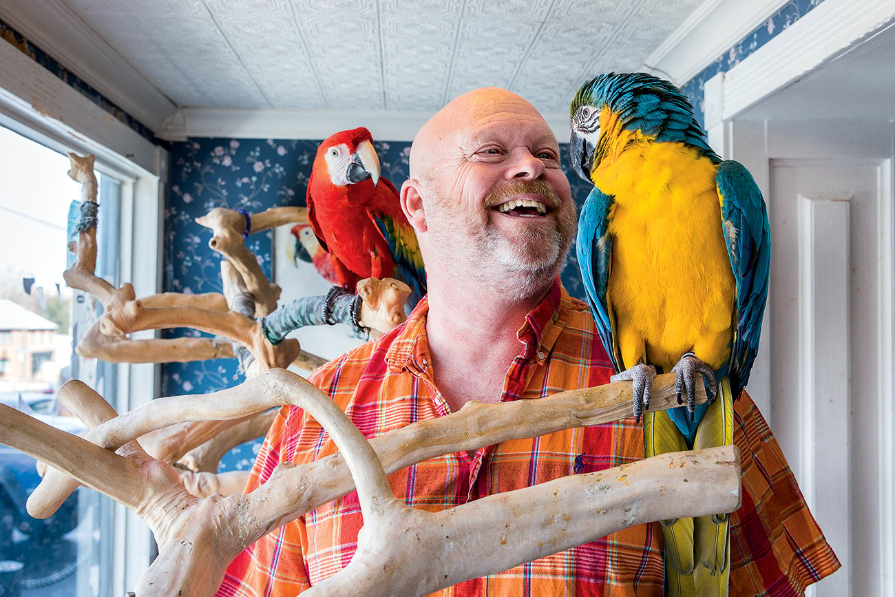 Store owner Ed Willis with two macaws. Photograph by April Greer.