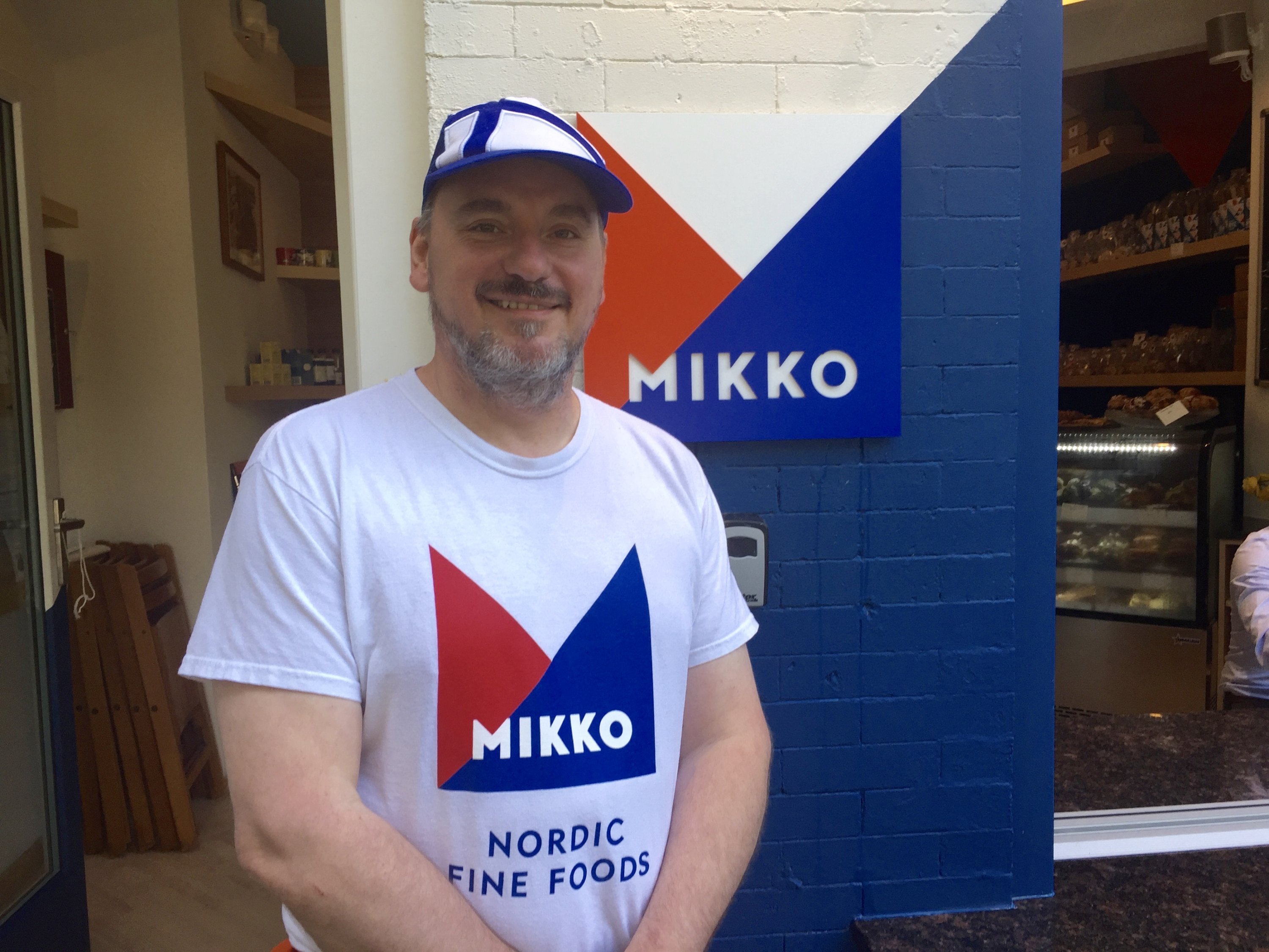 Chef Mikko Kosonen (who is wearing a hat in the pattern of the flag of Finland) stands in front of his new restaurant, Mikko. Photograph by Helen Carefoot.