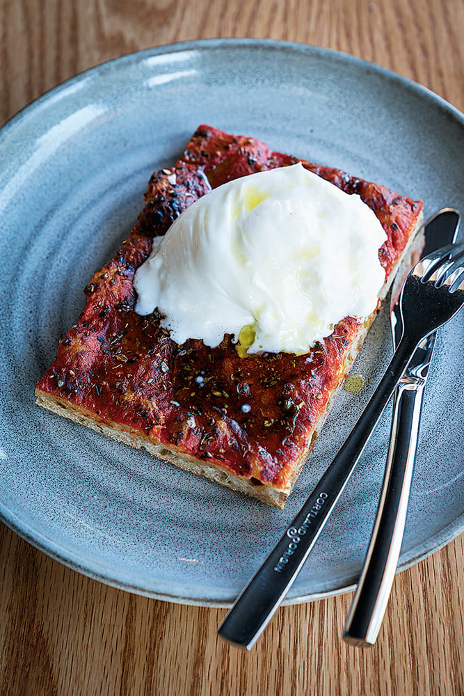 Pluma by Bluebird’s tomato pizza topped with burrata.