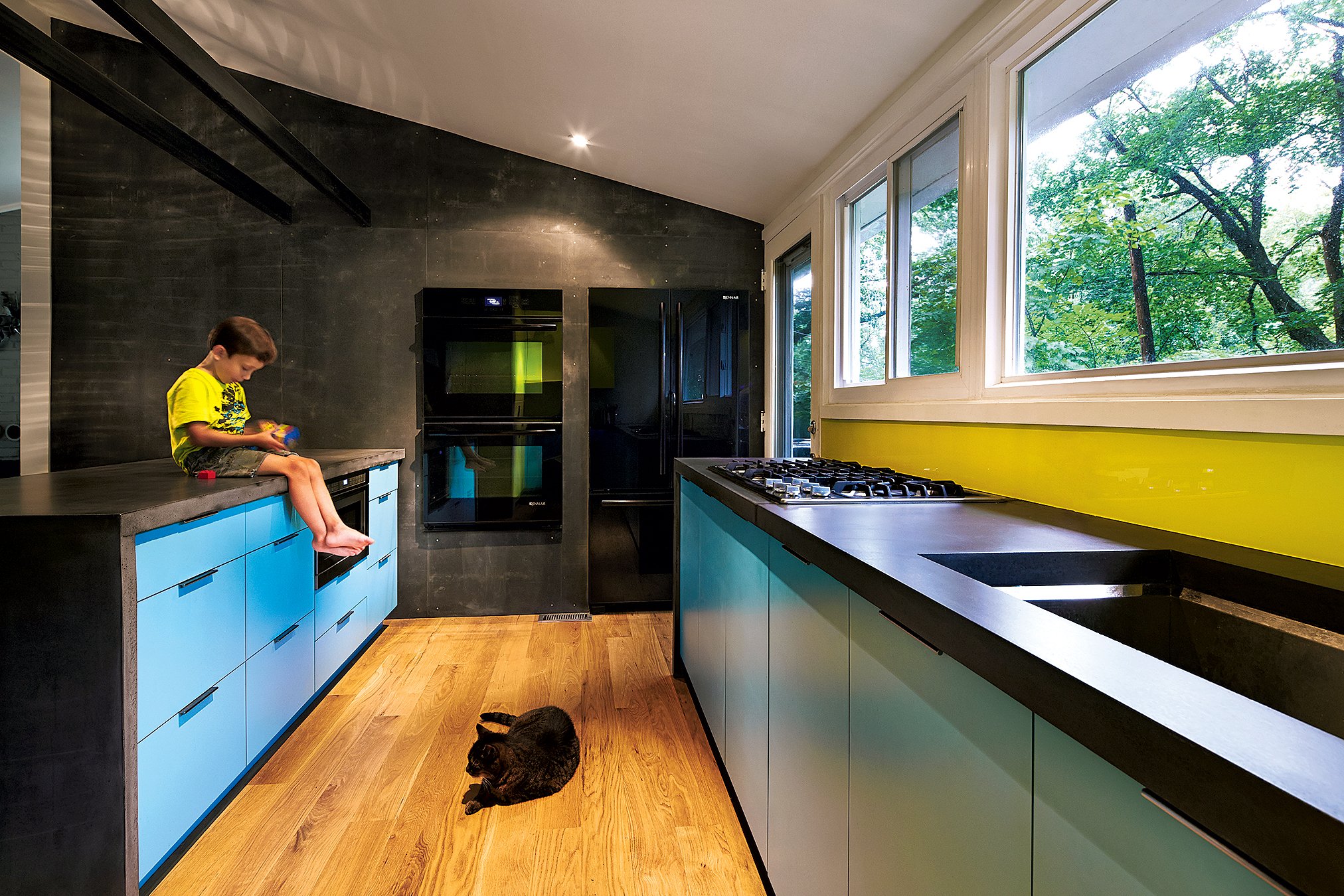 Black concrete counters and a wall clad in Viroc—a matte cement-board paneling—help tone down the bright shades in architect Janet Bloomberg’s own kitchen. Photographs courtesy of Kube Architects. 