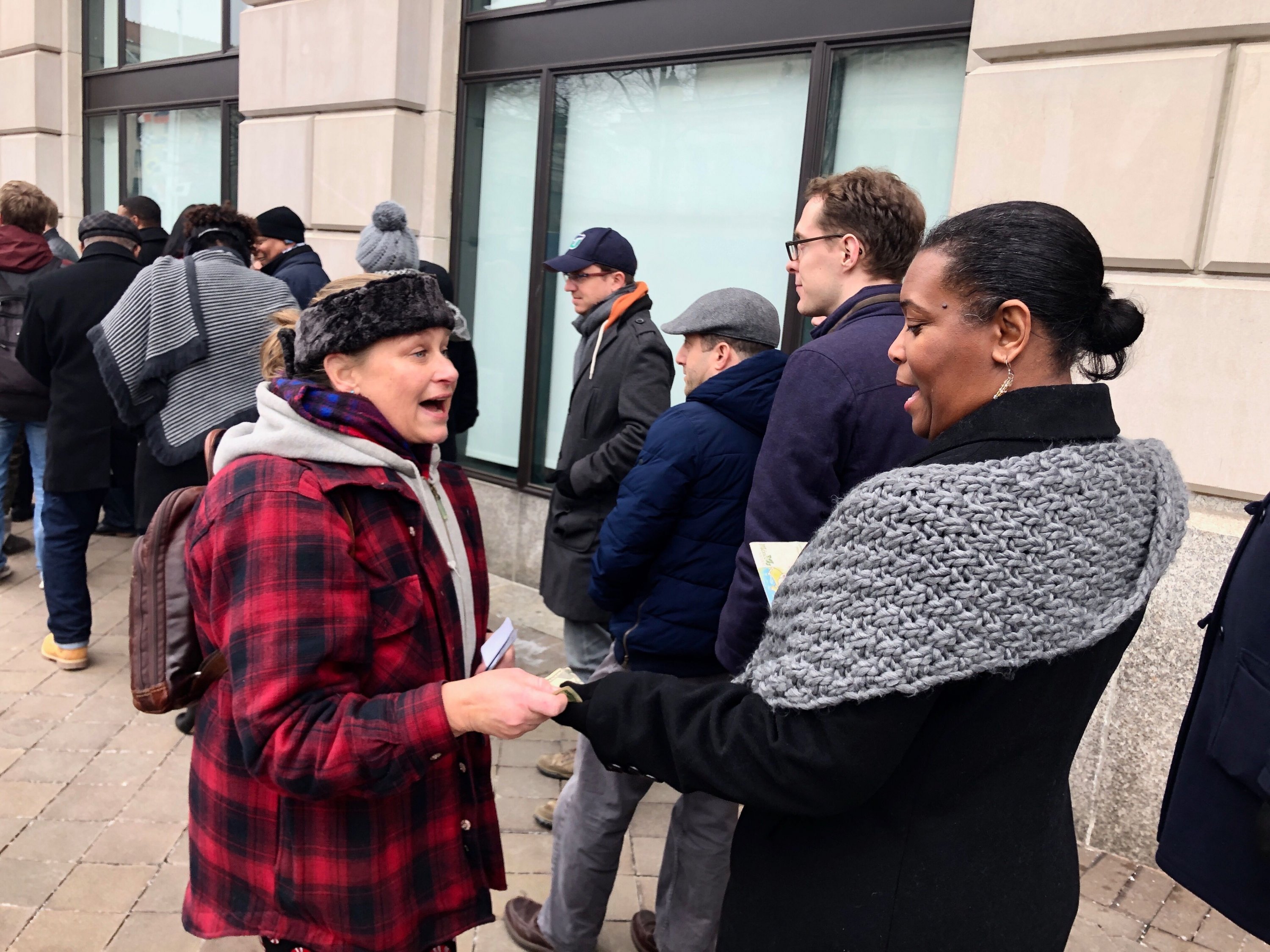 Mary Wilkinson handing out her money at the Chefs for Feds furlough cafe. Photography by Evy Mages.