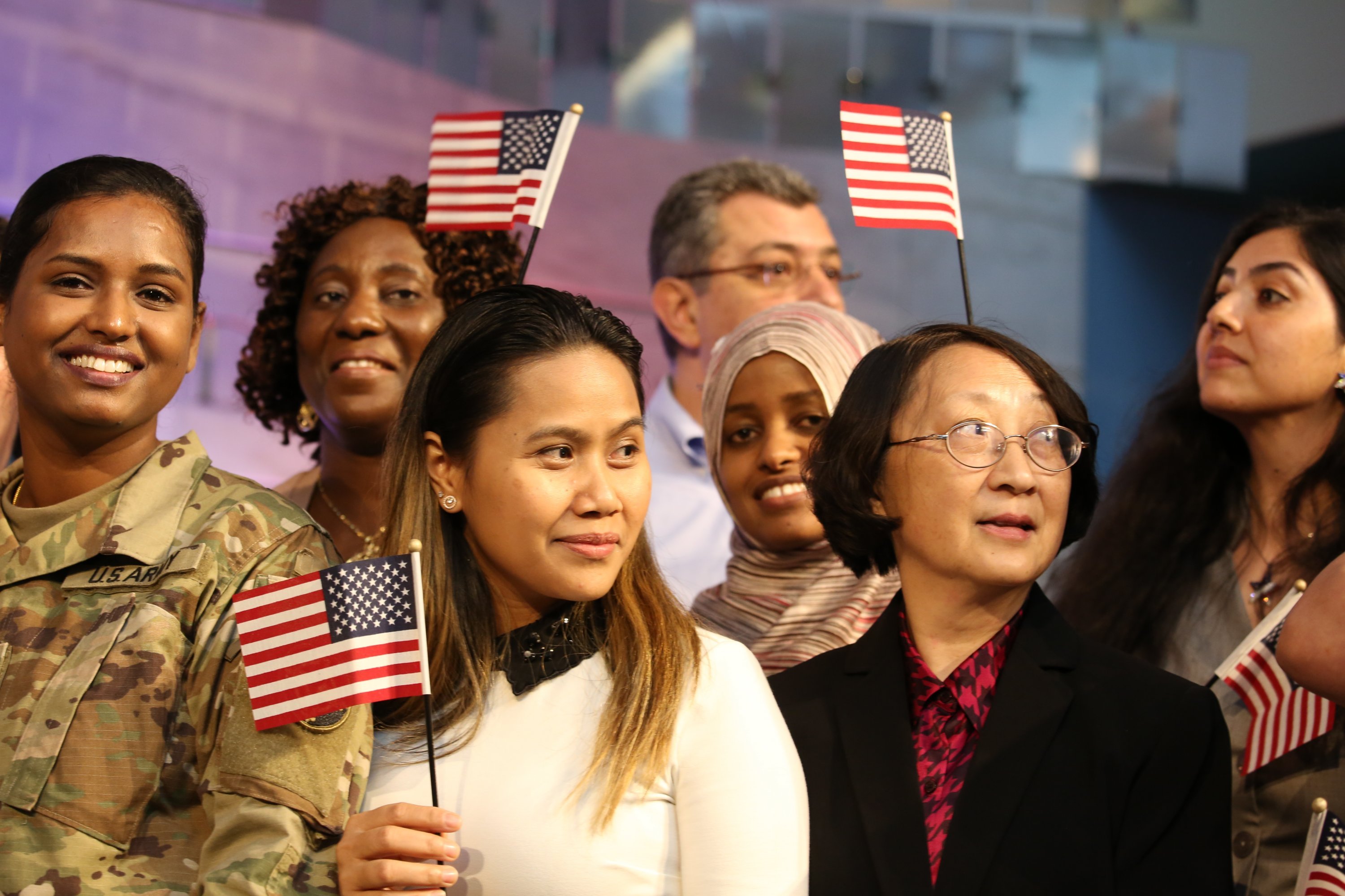 Photographs of Immigrants Becoming U.S. Citizens: Newly minted U.S. citizens wave their flags during a naturalization service at the American History Museum.