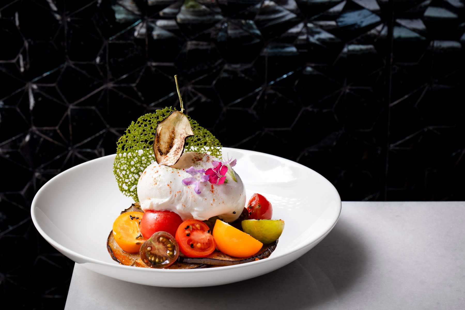 Eggplant, heirloom tomatoes, and burrata pay tribute to Punjabi dairy farmers in Italy. Photograph courtesy of Punjab Grill. 