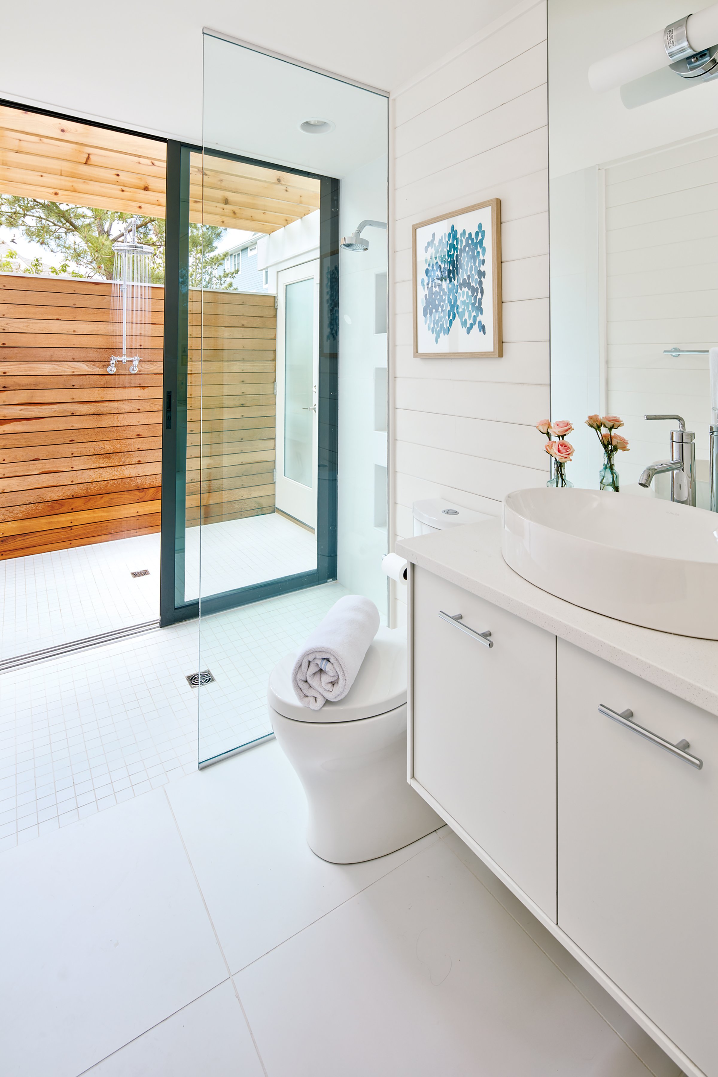 The lower level was reconfigured into a luxurious master suite, including this bathroom with a shower that opens to the outdoors via the glass slider. Photograph by Dana Hoff.