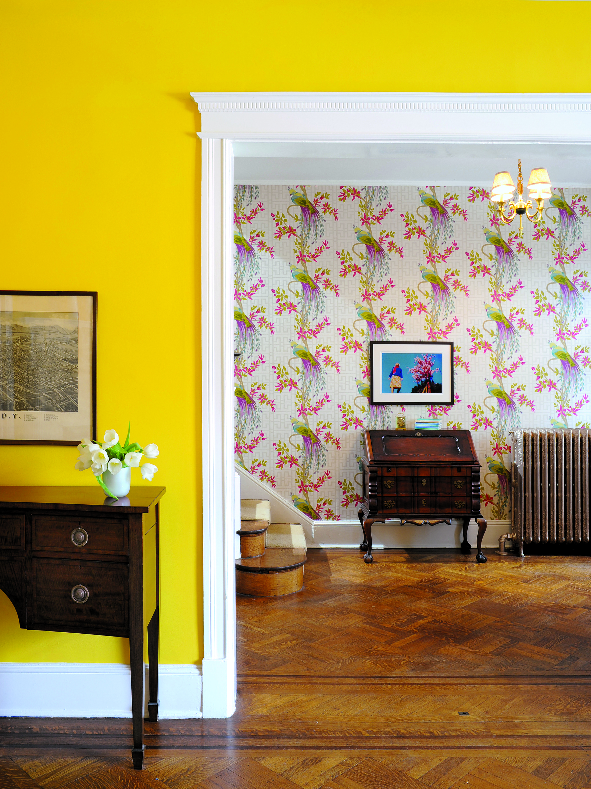 Off the Wall: Sunny yellow paint and Nina Campbell's "Paradiso" wallpaper enliven the foyer. Photograph by Michael Wilkinson. 