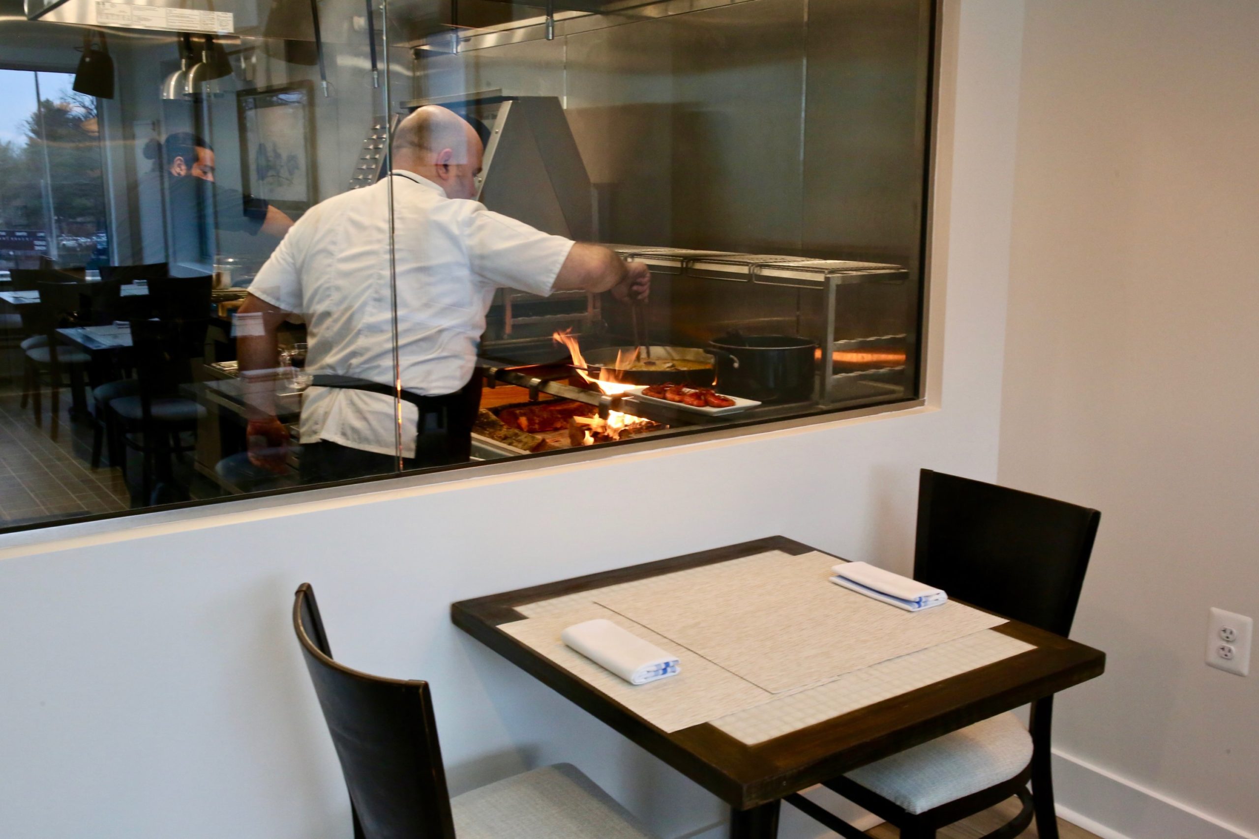 Chef Danny Lledó cooks paella in the glass-enclosed kitchen. Photo by Evy Mages.