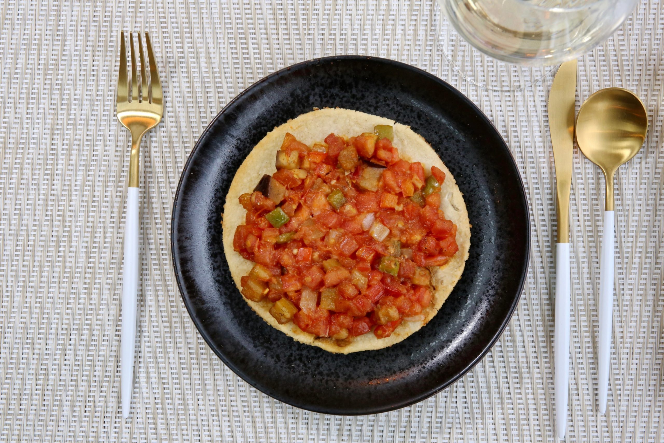 A tomato-topped flatbread is crisped in the green egg over orange wood. Photo by Evy Mages.