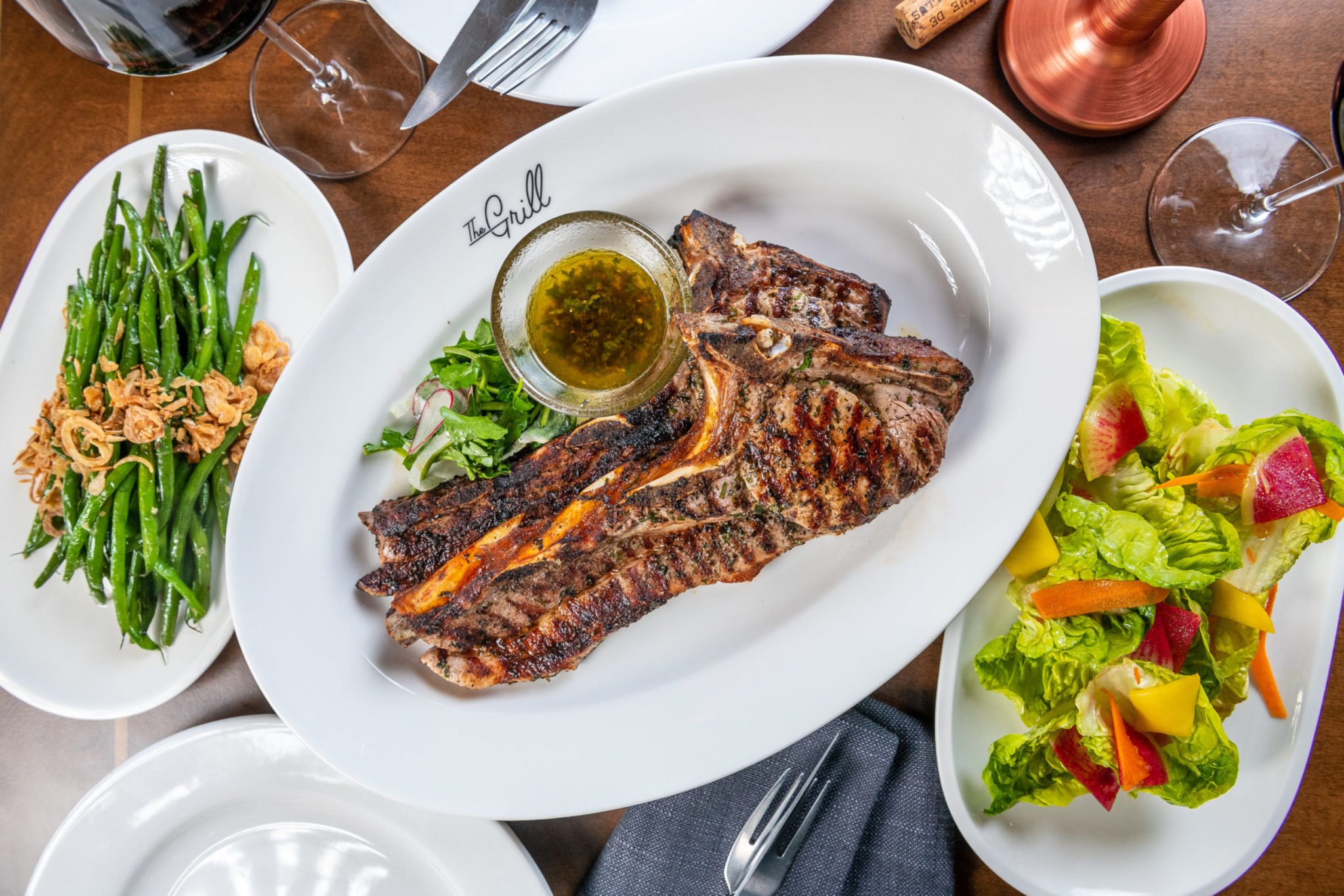 A pork chop is cooked on charcoal and pecan wood. Photo by Rey Lopez.